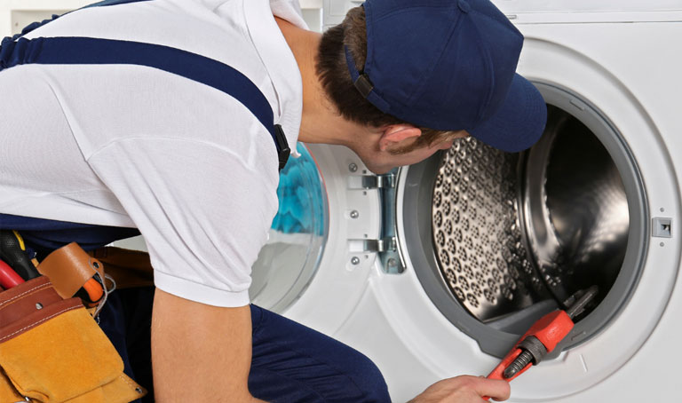 Plumber fixing a washing machine
